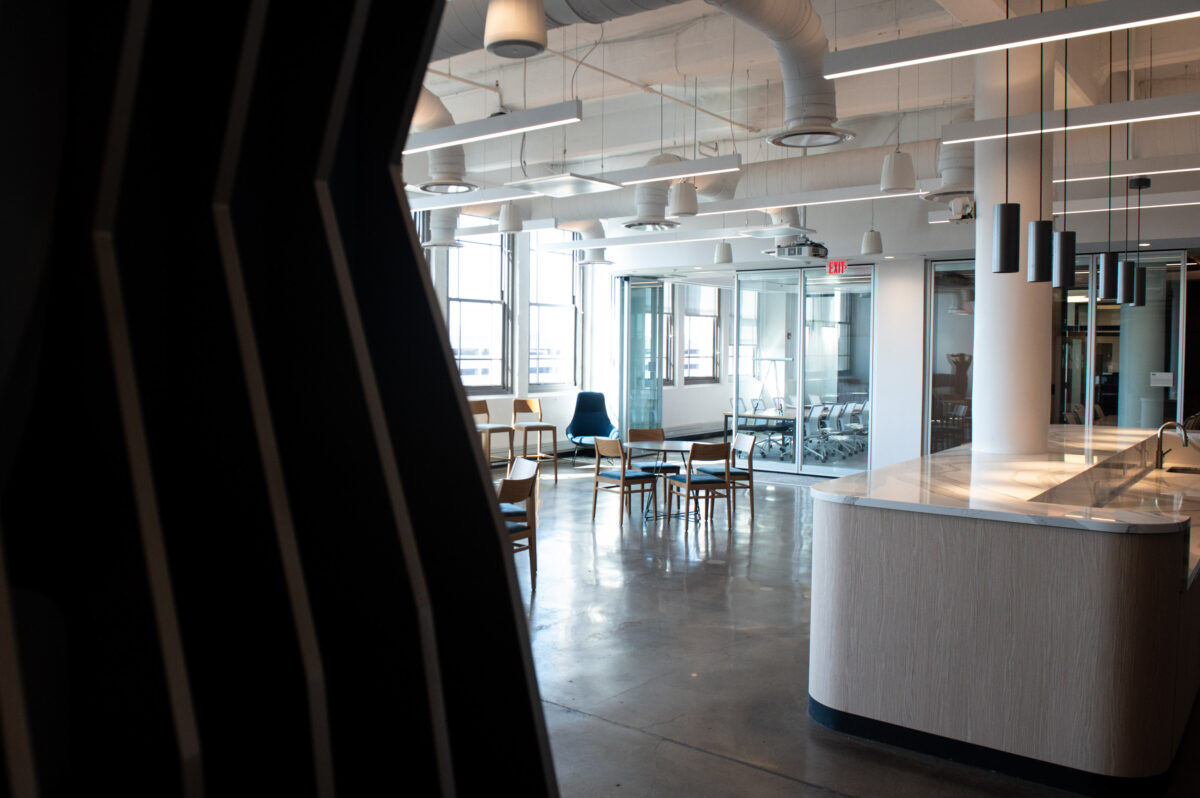 Modern office space with open seating and glass partitions.