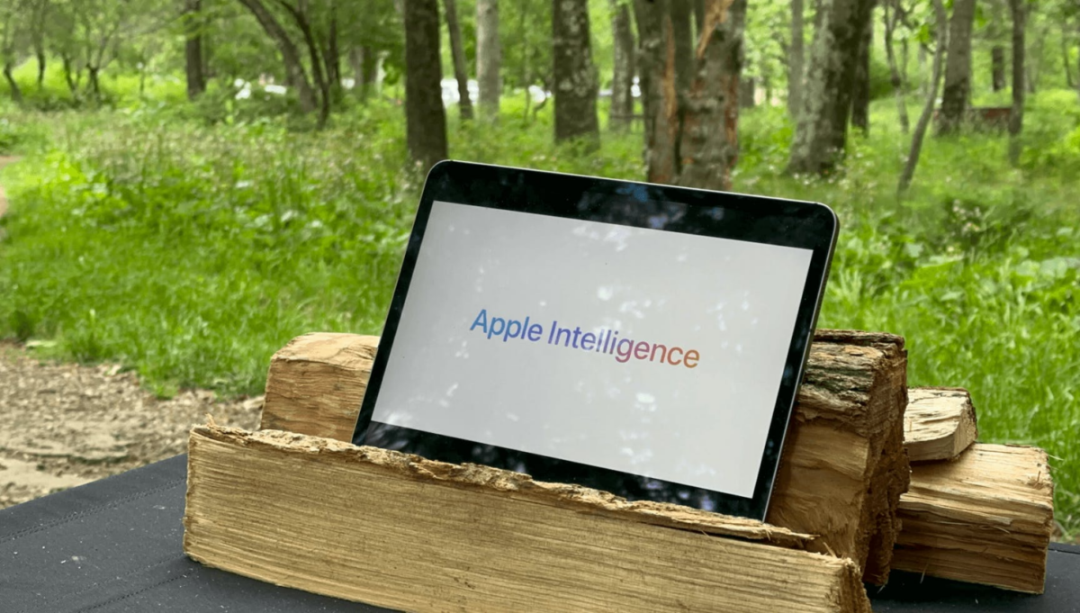 Apple Intelligence platform on black tablet that's placed on brown wood logs.