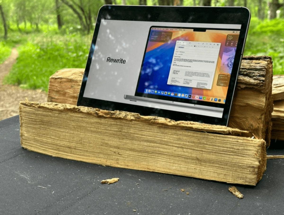 Apple Intelligence platform on black tablet that's placed on brown wood logs.