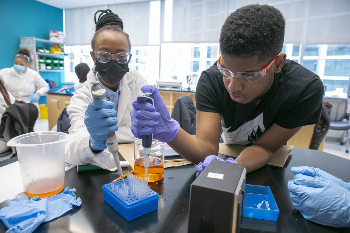 Two kids using pipettes. 