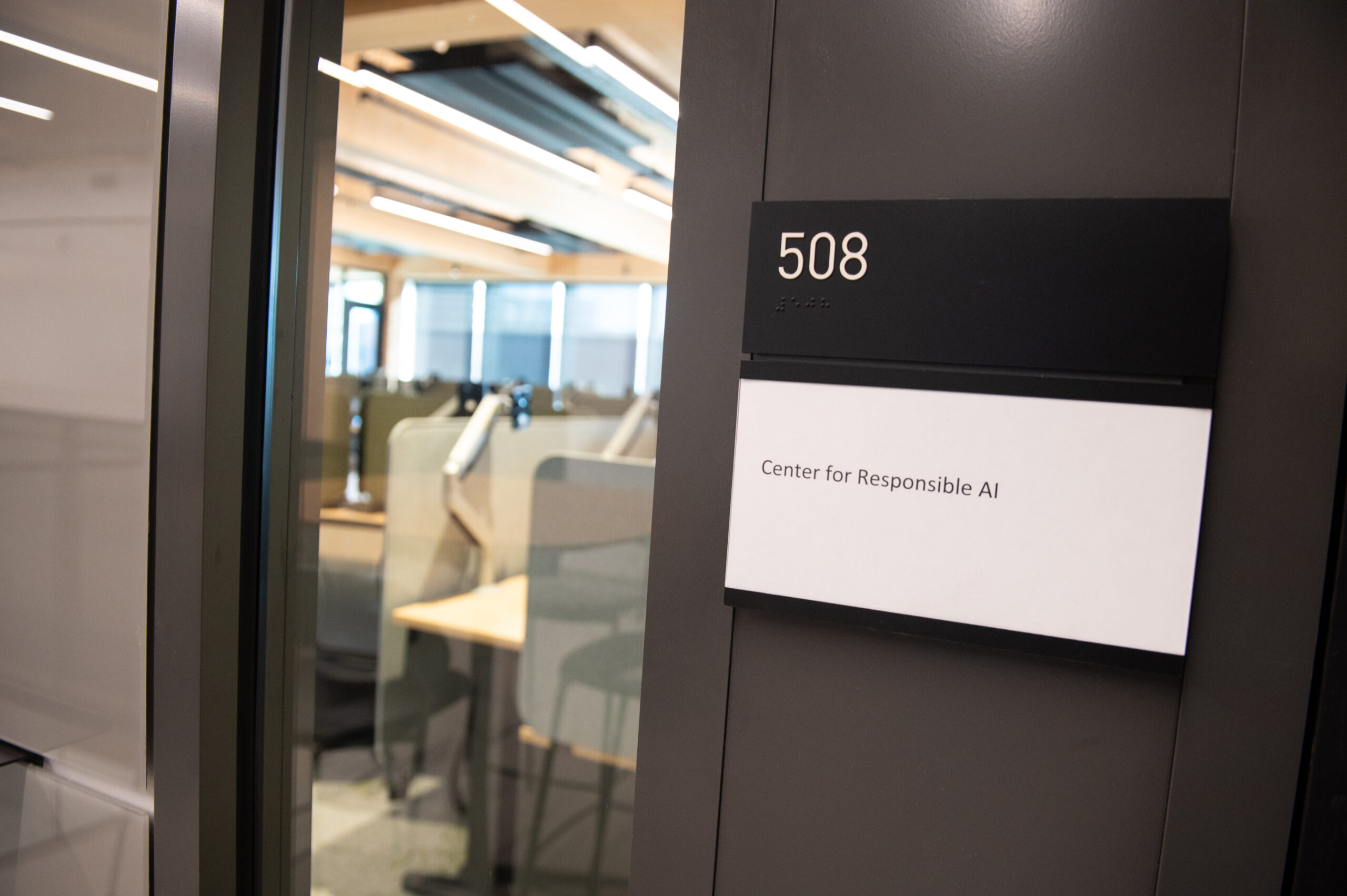 A doorway labeled "Center for Responsible AI" with room number 508; inside are desks and chairs in a well-lit office.