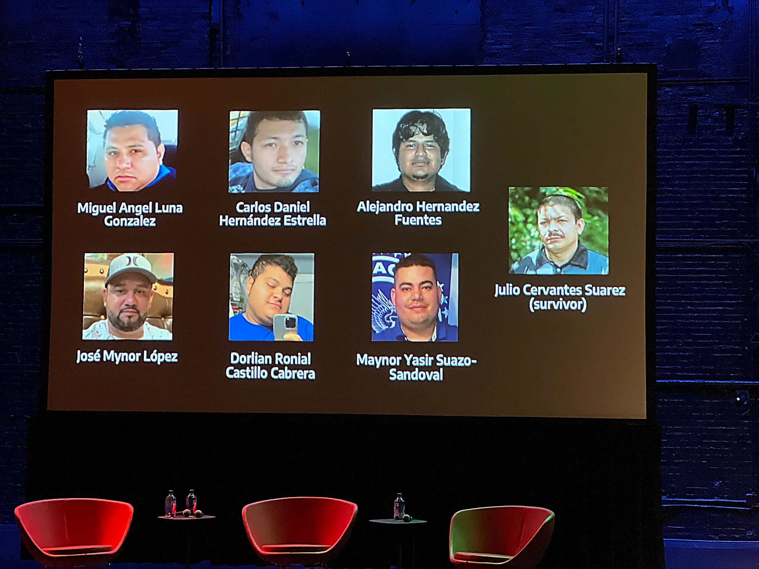 Images of seven Latino men on black screen with white text behind three empty red chairs