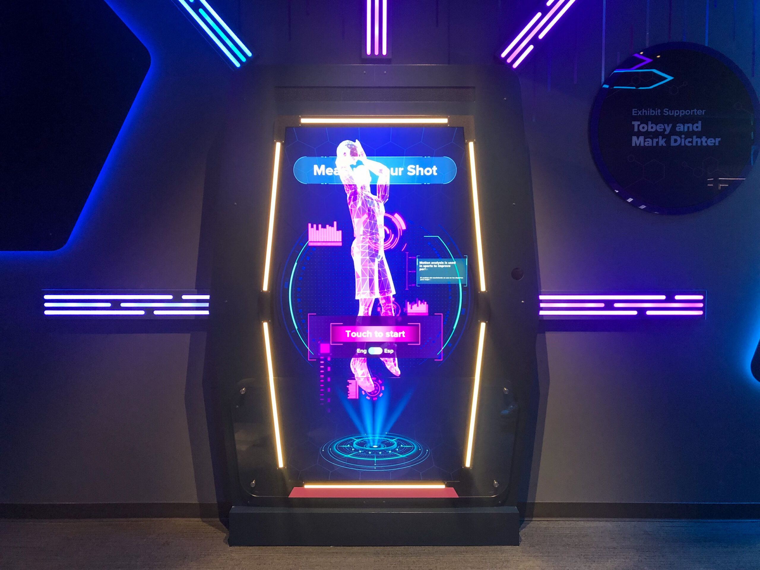 Interactive display with neon lights and graphics instructing users to "Touch to start.