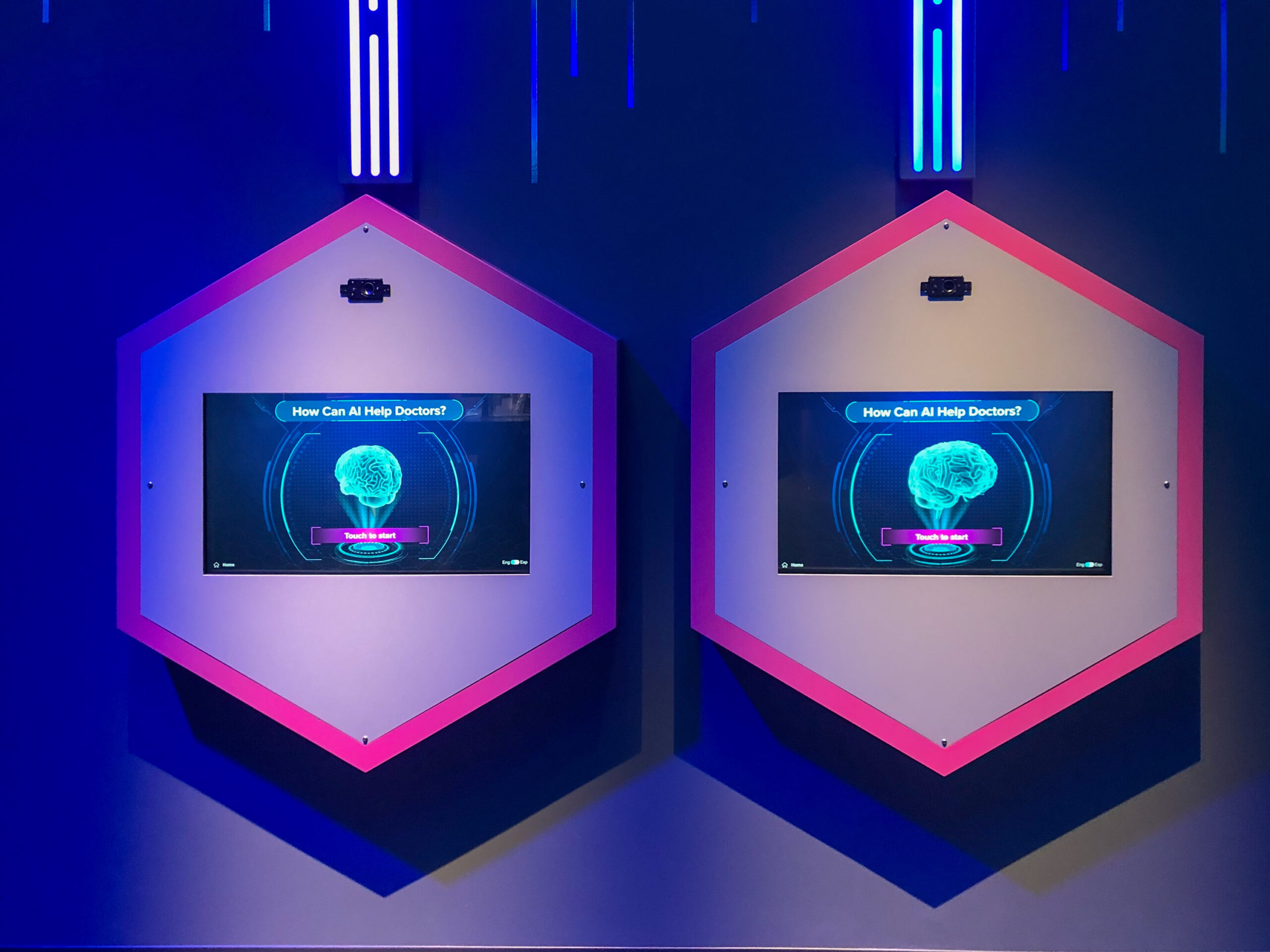 Two hexagonal screens display AI-themed graphics with the question, "How Can AI Help Doctors?" against a dark blue background with light strips above.